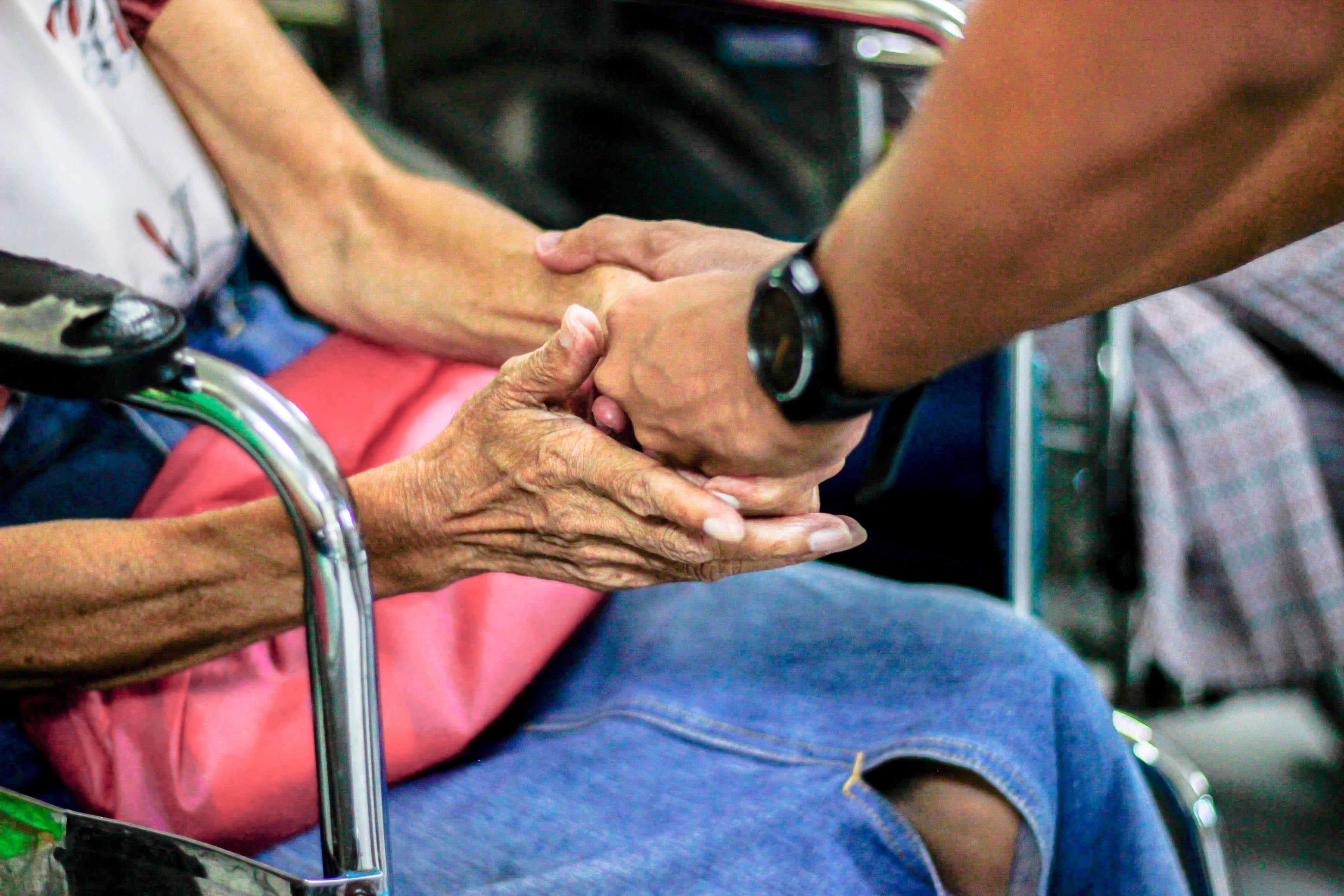 Man holding hand of elderly